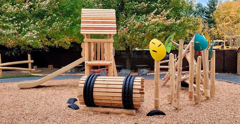 Custom wooden play structure in a designed landscape